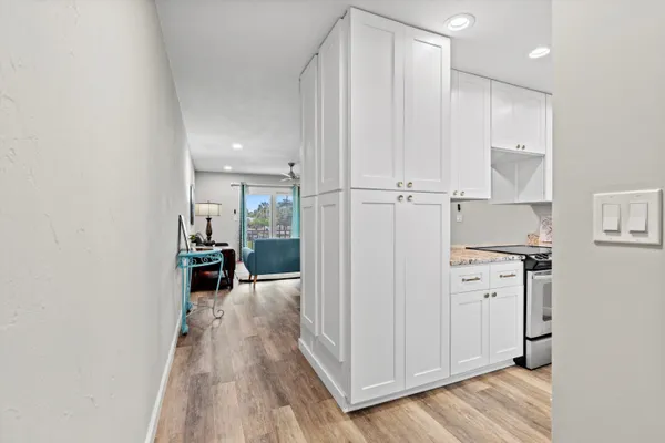 a view of a hallway with wooden floor and furniture