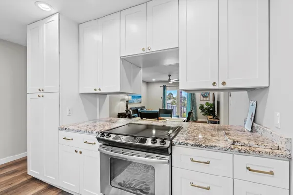a kitchen with granite countertop a stove sink and cabinets