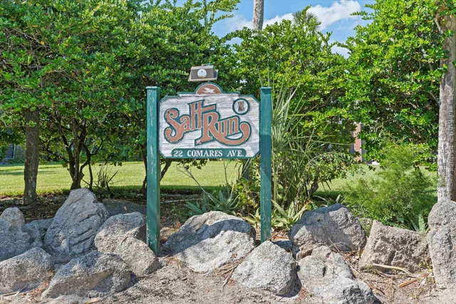 a view of a street sign under a large tree