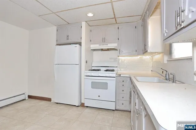 a kitchen with appliances a sink and cabinets