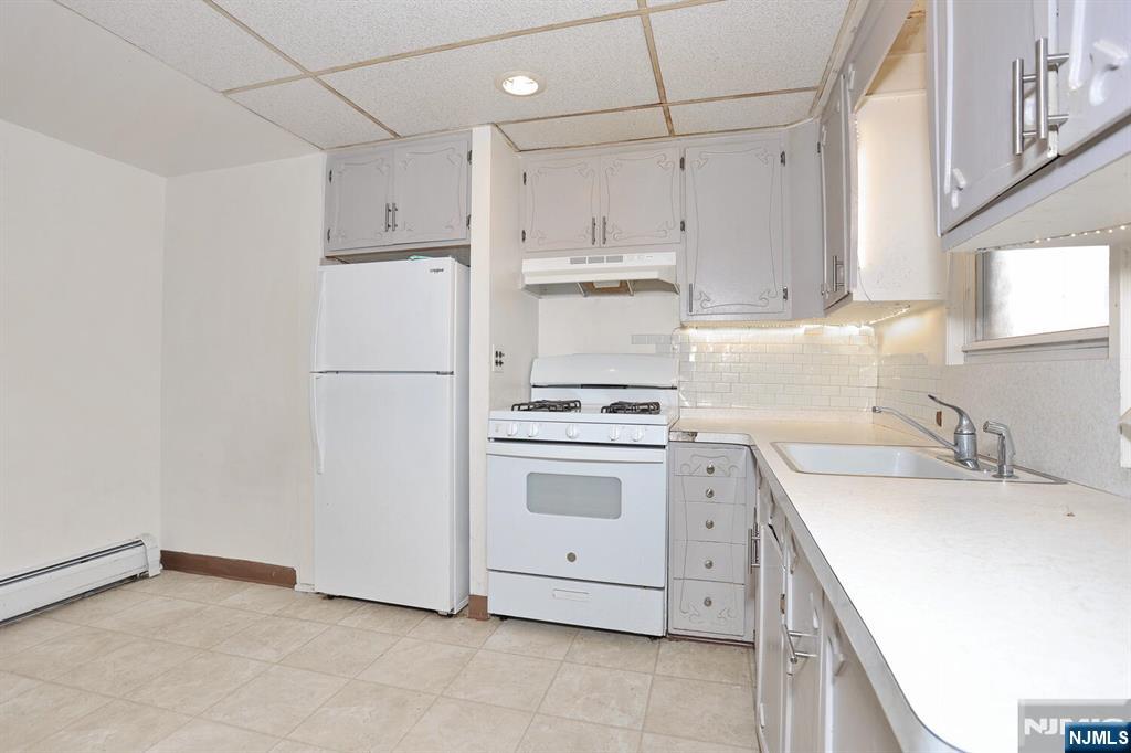 325 New Bridge Road Bergenfield, NJ 07621 - Photo 11 of 50 a kitchen with appliances a sink and cabinets