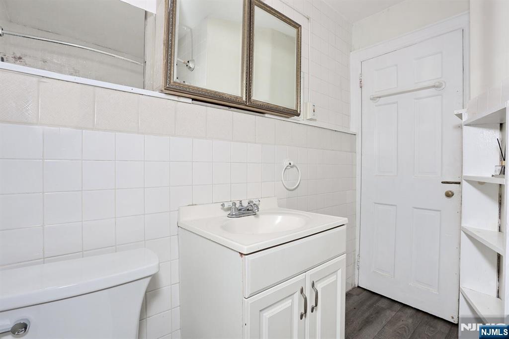 325 New Bridge Road Bergenfield, NJ 07621 - Photo 17 of 50 a bathroom with a sink a toilet and a mirror