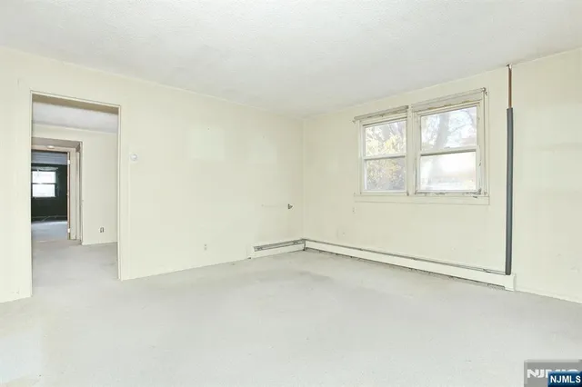 a view of kitchen with cabinets and window