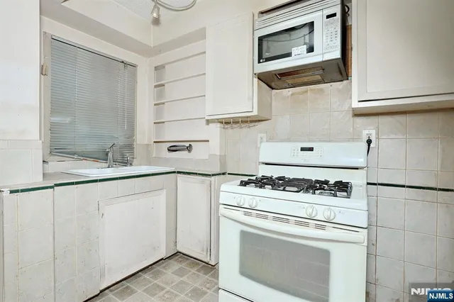 an empty room with a ceiling fan and window