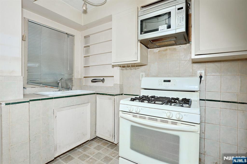 325 New Bridge Road Bergenfield, NJ 07621 - Photo 25 of 50 a kitchen with cabinets and appliances