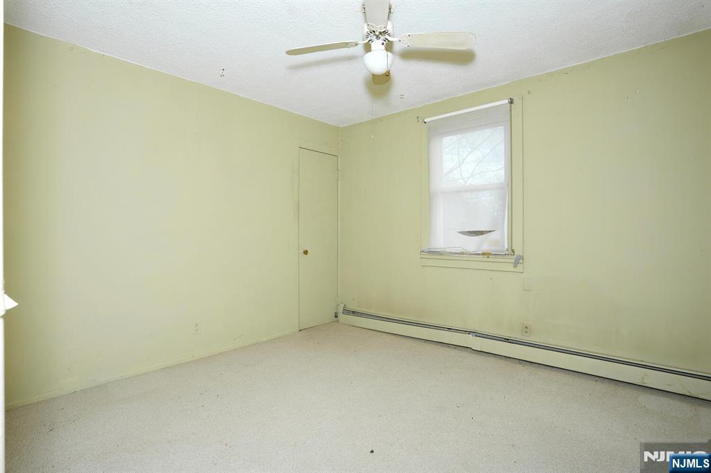 325 New Bridge Road Bergenfield, NJ 07621 - Photo 26 of 50 an empty room with a window and a fan