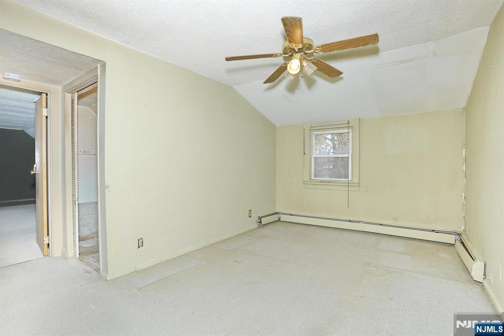 325 New Bridge Road Bergenfield, NJ 07621 - Photo 27 of 50 an empty room with a ceiling fan and window