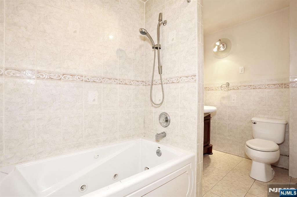 325 New Bridge Road Bergenfield, NJ 07621 - Photo 33 of 50 a bathroom with a bathtub and a shower