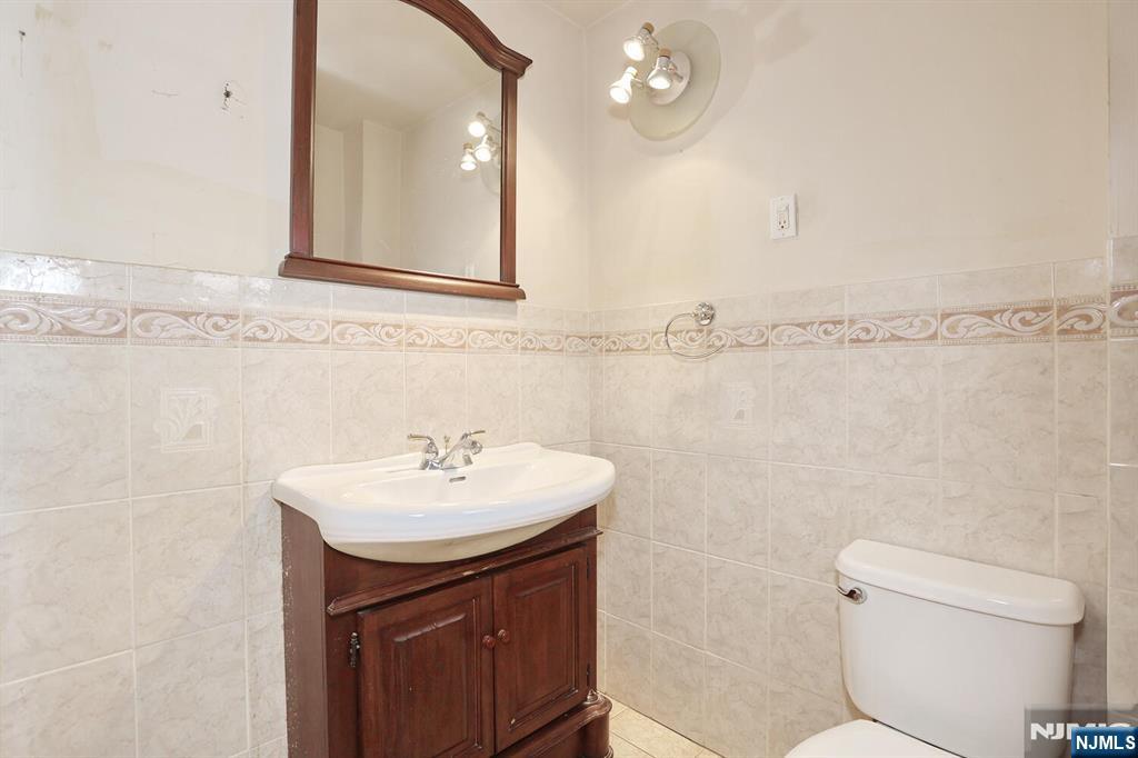 325 New Bridge Road Bergenfield, NJ 07621 - Photo 34 of 50 a bathroom with a sink a toilet and a mirror