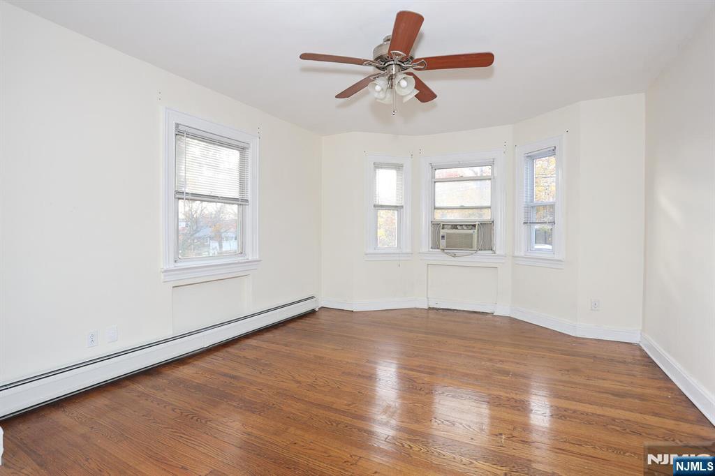 325 New Bridge Road Bergenfield, NJ 07621 - Photo 7 of 50 a view of empty room with wooden floor and fan