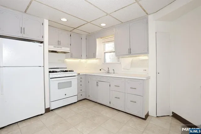 a kitchen with white cabinets and white appliances
