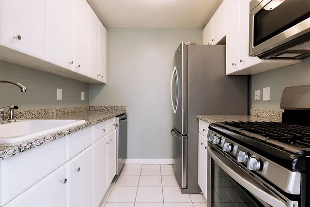 a kitchen with stainless steel appliances granite countertop a refrigerator and a sink