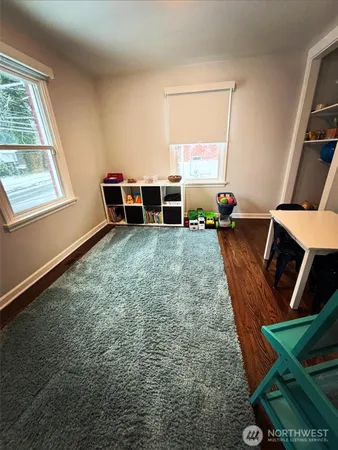 a view of an empty room with furniture and a window