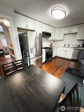 a kitchen with stainless steel appliances granite countertop a refrigerator a stove and a sink with cabinets