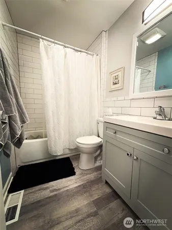 a bathroom with a sink a toilet a window and a mirror