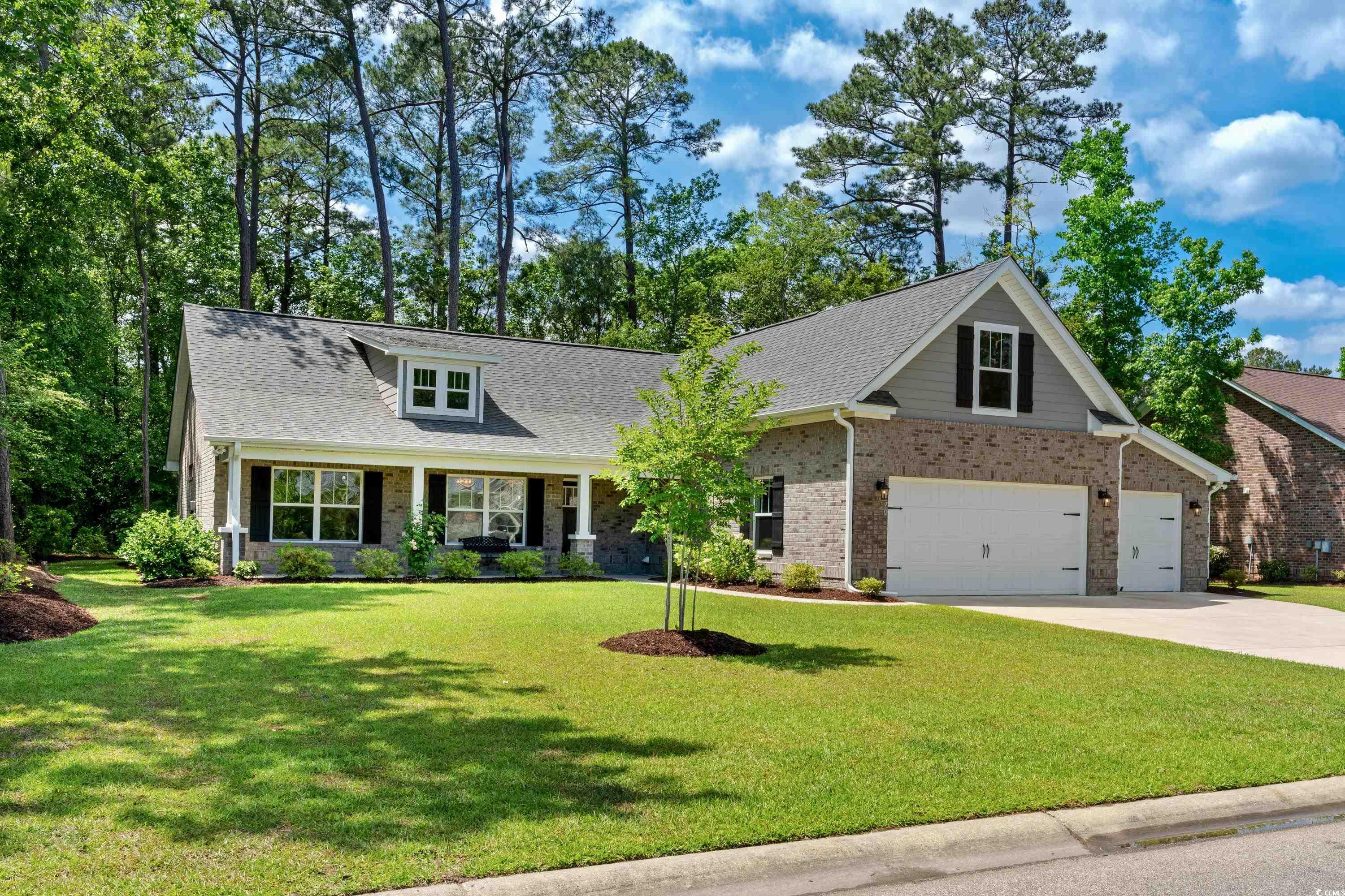 Craftsman house featuring brick siding, driveway,