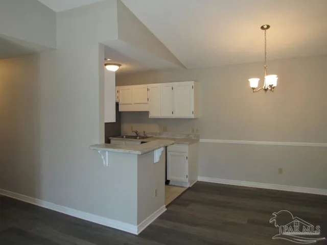 a kitchen with a sink cabinets and wooden floor