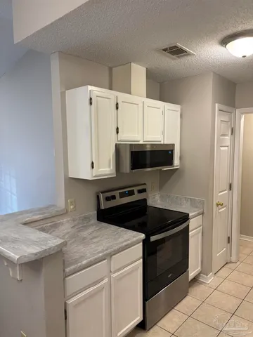 a kitchen with granite countertop white cabinets and white appliances