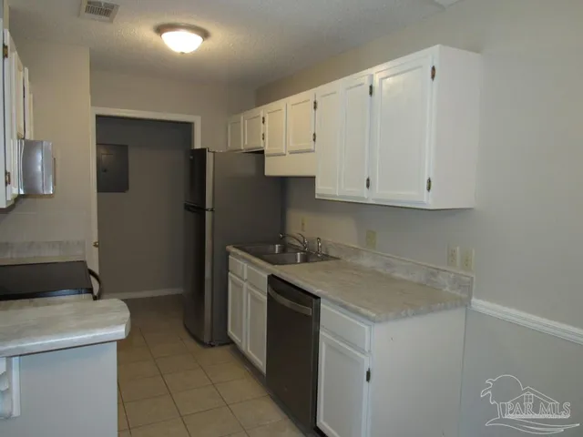 a kitchen with stainless steel appliances granite countertop a refrigerator and a stove