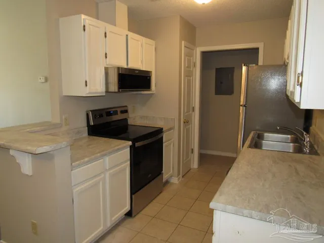 a kitchen with stainless steel appliances a stove microwave and sink