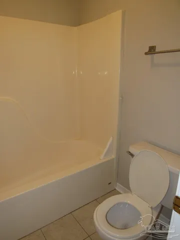a white toilet sitting next to a bath tub and a shower