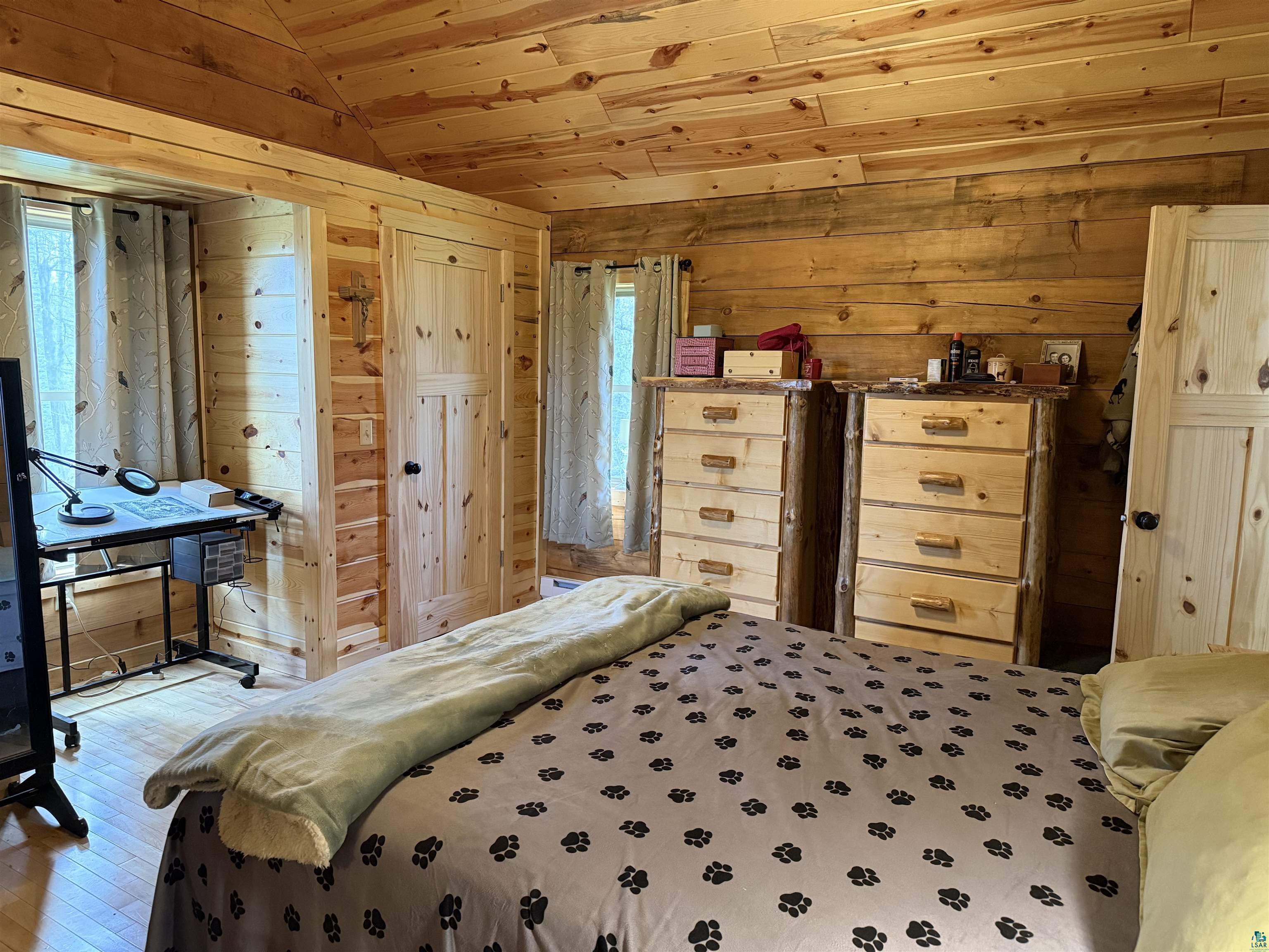 37590 Degerstrom Road Askov, MN 55704 - Photo 19 of 53 Room featuring natural wood plank walls and ceiling, wood-finish flooring, and a window with a wooded backdrop