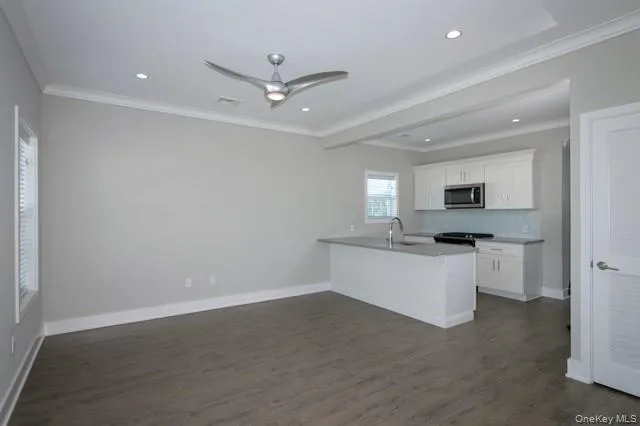 a kitchen with white cabinets and sink