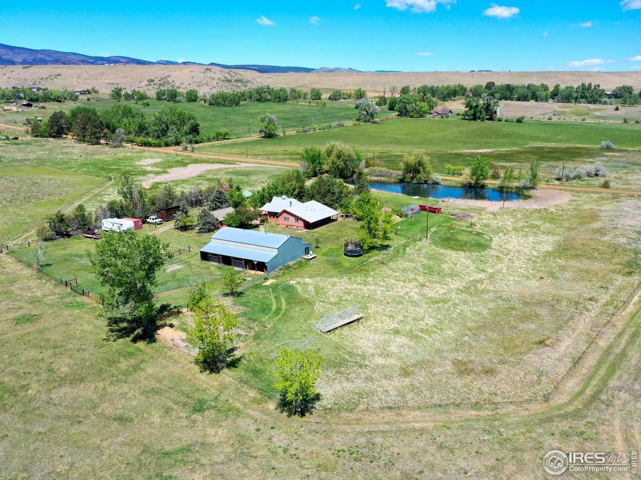 5196 Oxford Road Longmont, CO 80503 - Photo 12 of 38 a view of a lake with a yard and large trees