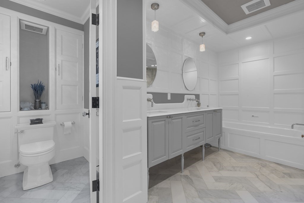 23 Eliot Street, Unit 1 Boston, MA 02130 - Photo 30 of 39 a bathroom with a double vanity sink a toilet and a bathtub