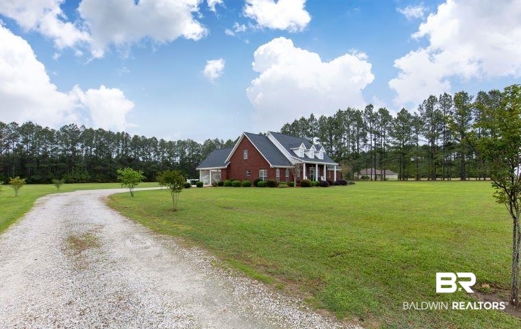 24541 Baldwin Beach Expressway Robertsdale, AL 36567 - Photo 4 of 51 View of front of property featuring a front lawn and gravel driveway