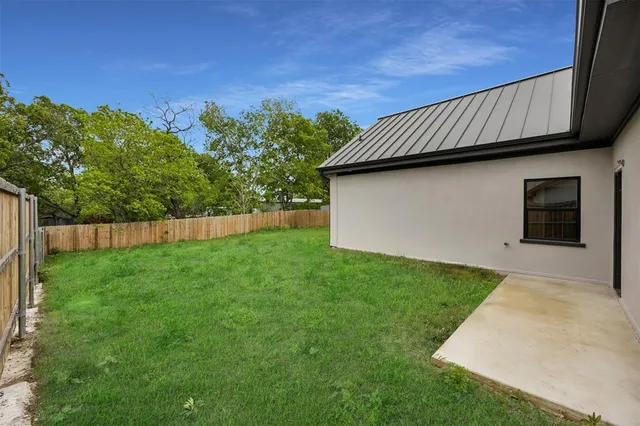 a view of a backyard with plants and a fence