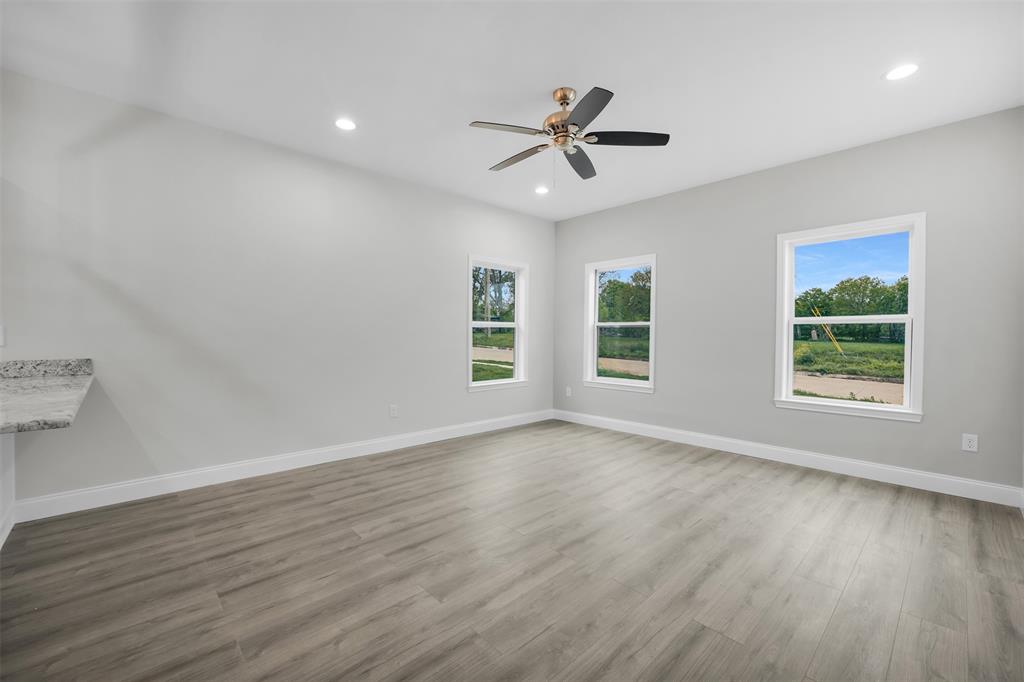 407 Dallas Street Rice, TX 75155 - Photo 6 of 25 a view of an empty room with wooden floor and a window