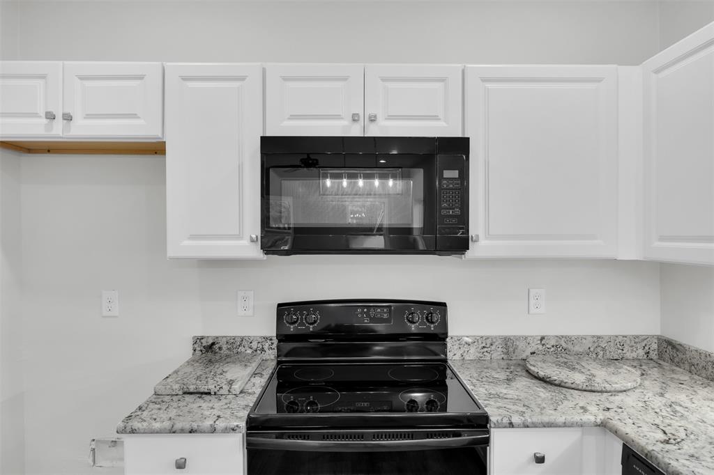 407 Dallas Street Rice, TX 75155 - Photo 10 of 25 a kitchen with granite countertop a stove and a microwave