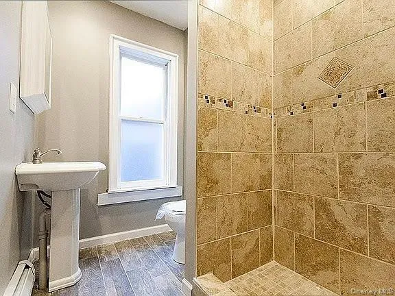 a bathroom with a sink a toilet and shower