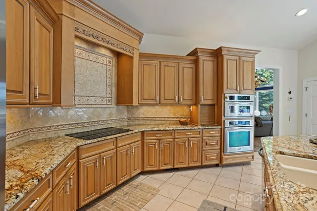 a kitchen with stainless steel appliances granite countertop a sink and cabinets