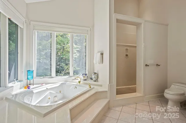 a spacious bathroom with a tub sink and mirror