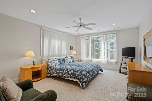 a bedroom with a bed a couch and a flat screen television