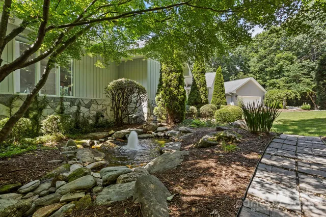 a view of a house with a yard and tree s