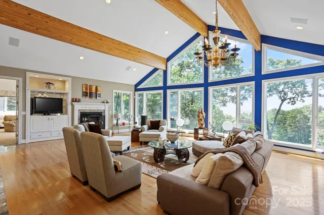 a living room with furniture a fireplace and a large window