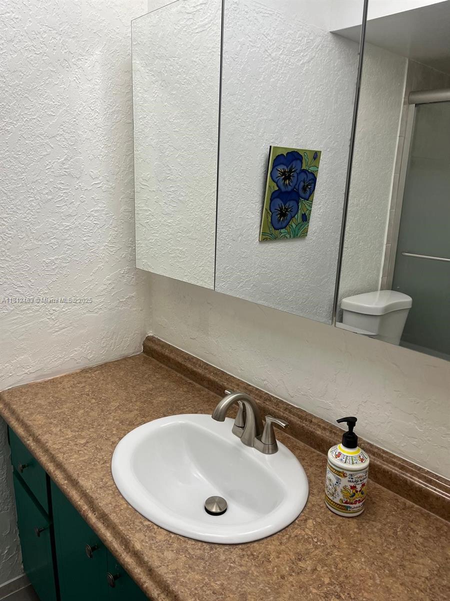 620 Northeast 12th Avenue, Unit 107 Hallandale Beach, FL 33009 - Photo 11 of 16 a bathroom with a sink and a mirror