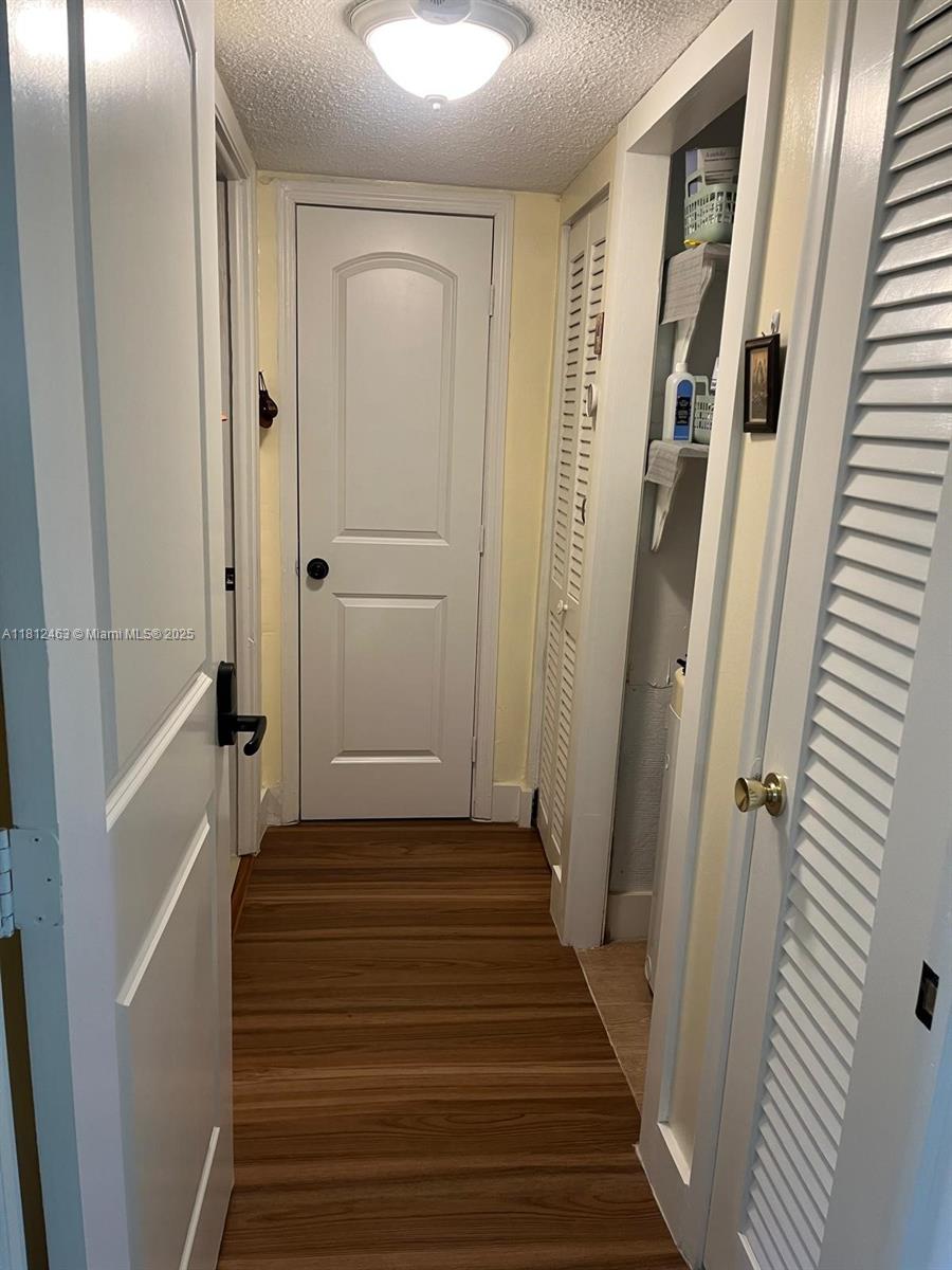 620 Northeast 12th Avenue, Unit 107 Hallandale Beach, FL 33009 - Photo 14 of 16 a view of a hallway with wooden floor and staircase