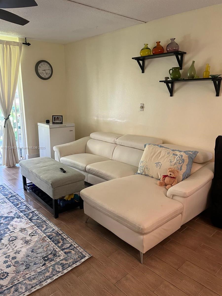 620 Northeast 12th Avenue, Unit 107 Hallandale Beach, FL 33009 - Photo 2 of 16 a living room with furniture and a mirror