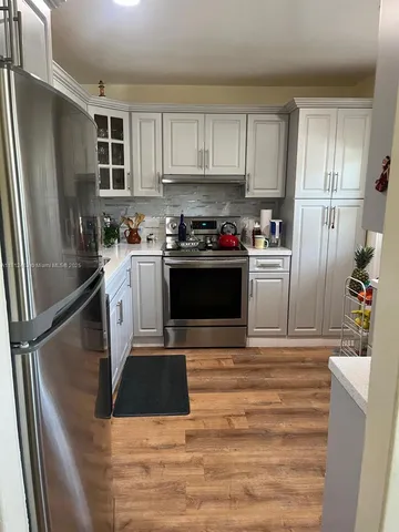 a kitchen with granite countertop a refrigerator stove and sink