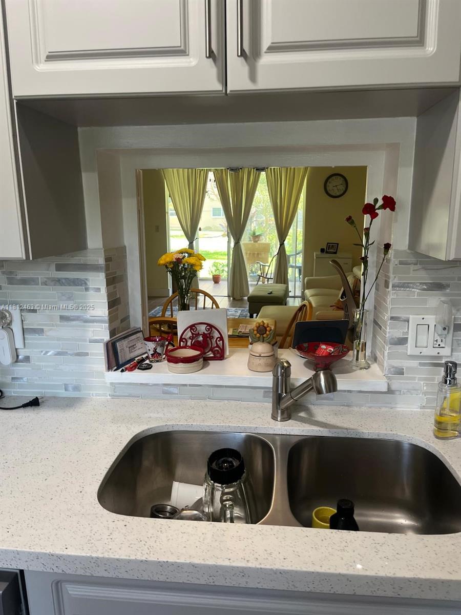 620 Northeast 12th Avenue, Unit 107 Hallandale Beach, FL 33009 - Photo 6 of 16 a kitchen sink with a granite countertop window and cabinets