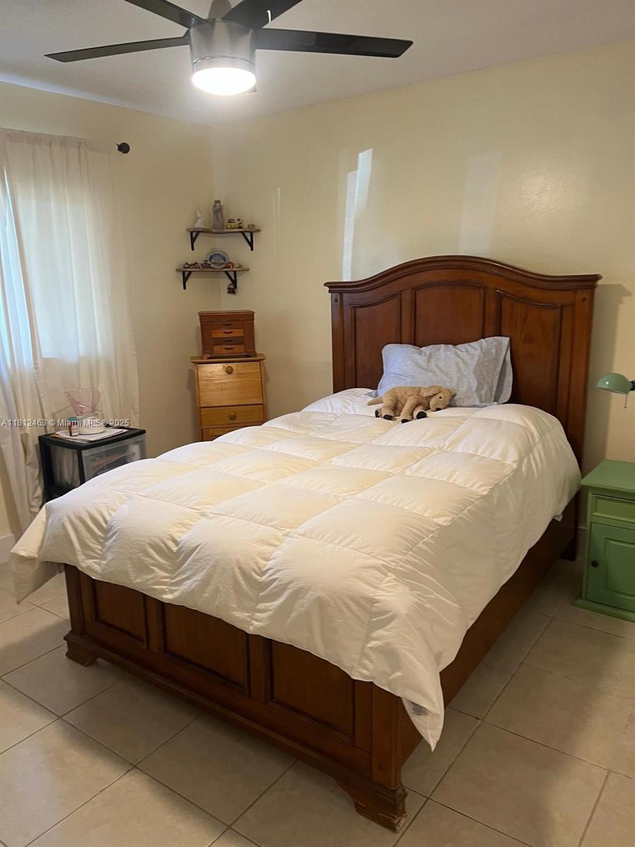 620 Northeast 12th Avenue, Unit 107 Hallandale Beach, FL 33009 - Photo 7 of 16 a bedroom with a bed and a potted plant on the dresser