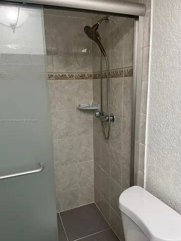 a bathroom with a toilet and a shower