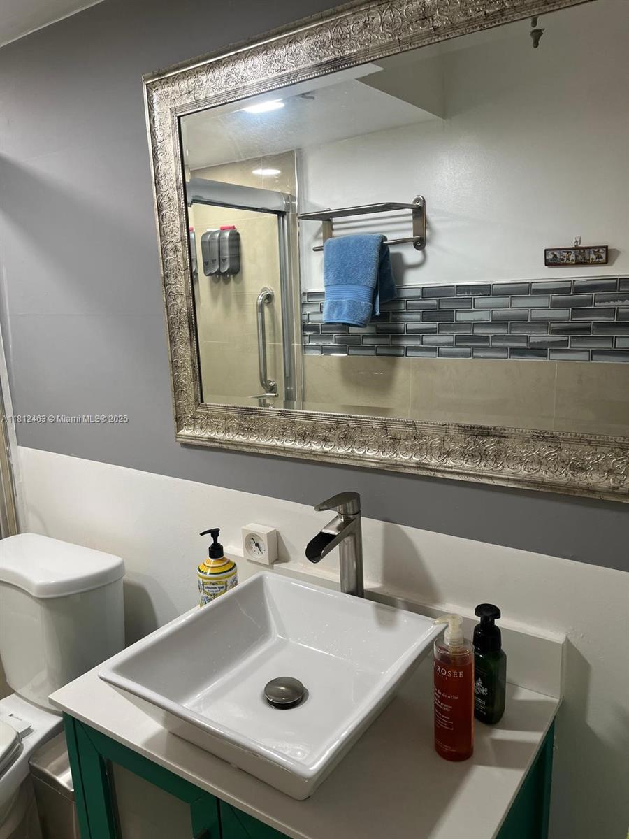 620 Northeast 12th Avenue, Unit 107 Hallandale Beach, FL 33009 - Photo 10 of 16 a bathroom with a sink and a mirror