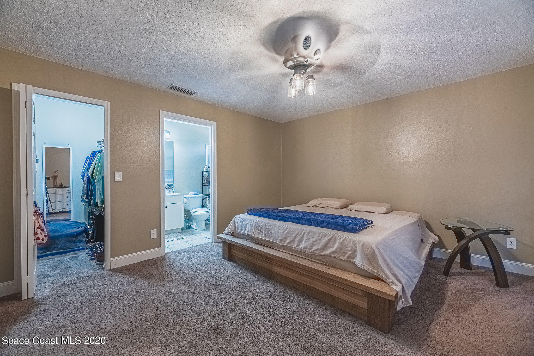 1240 Rabbit Street Southeast Palm Bay, FL 32909 - Photo 14 of 41 a bed sitting in a spacious bedroom next to a bathroom