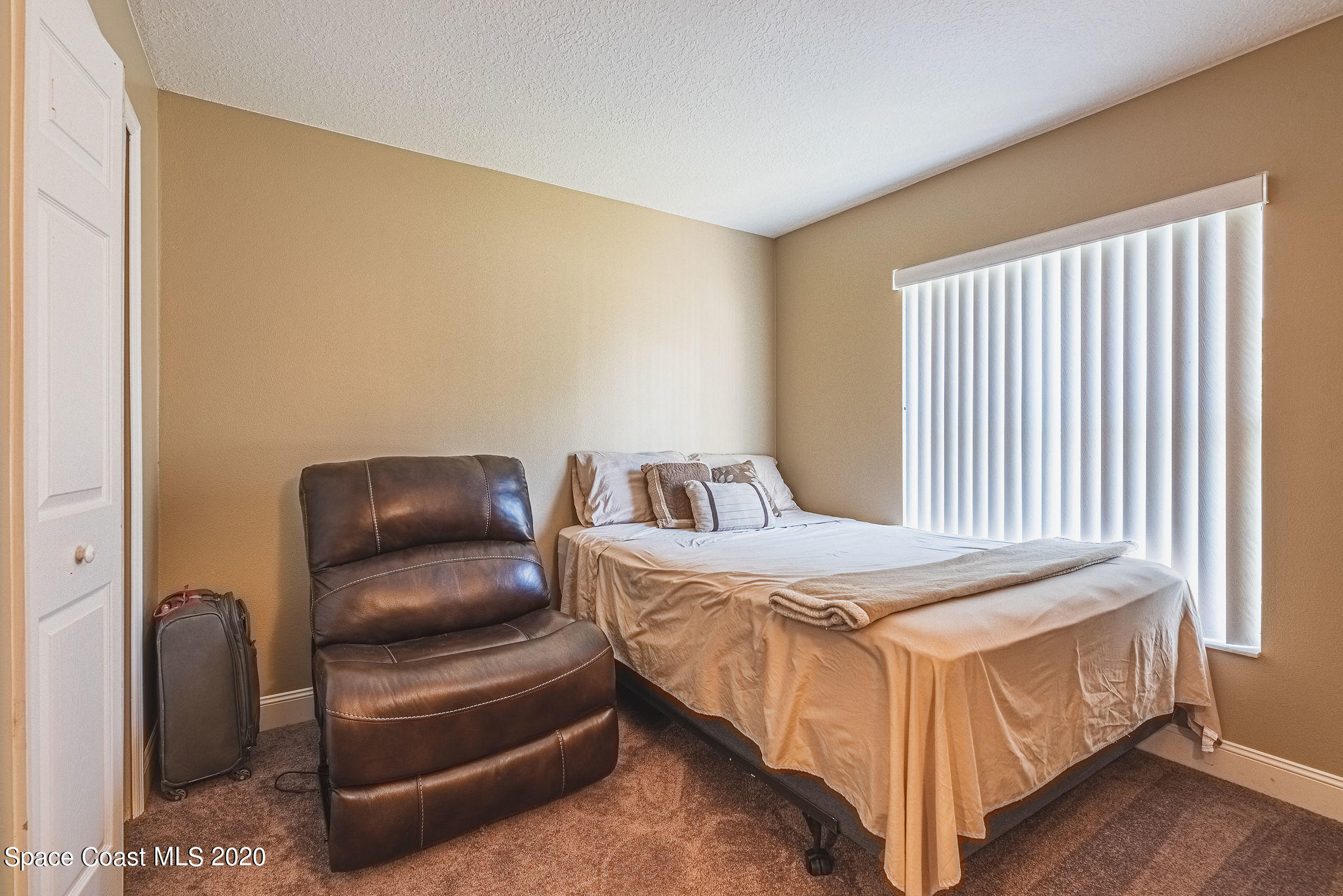 1240 Rabbit Street Southeast Palm Bay, FL 32909 - Photo 17 of 41 a bedroom with a bed and a chair