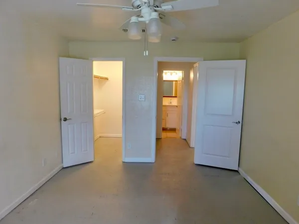 an empty room with fan and entrance